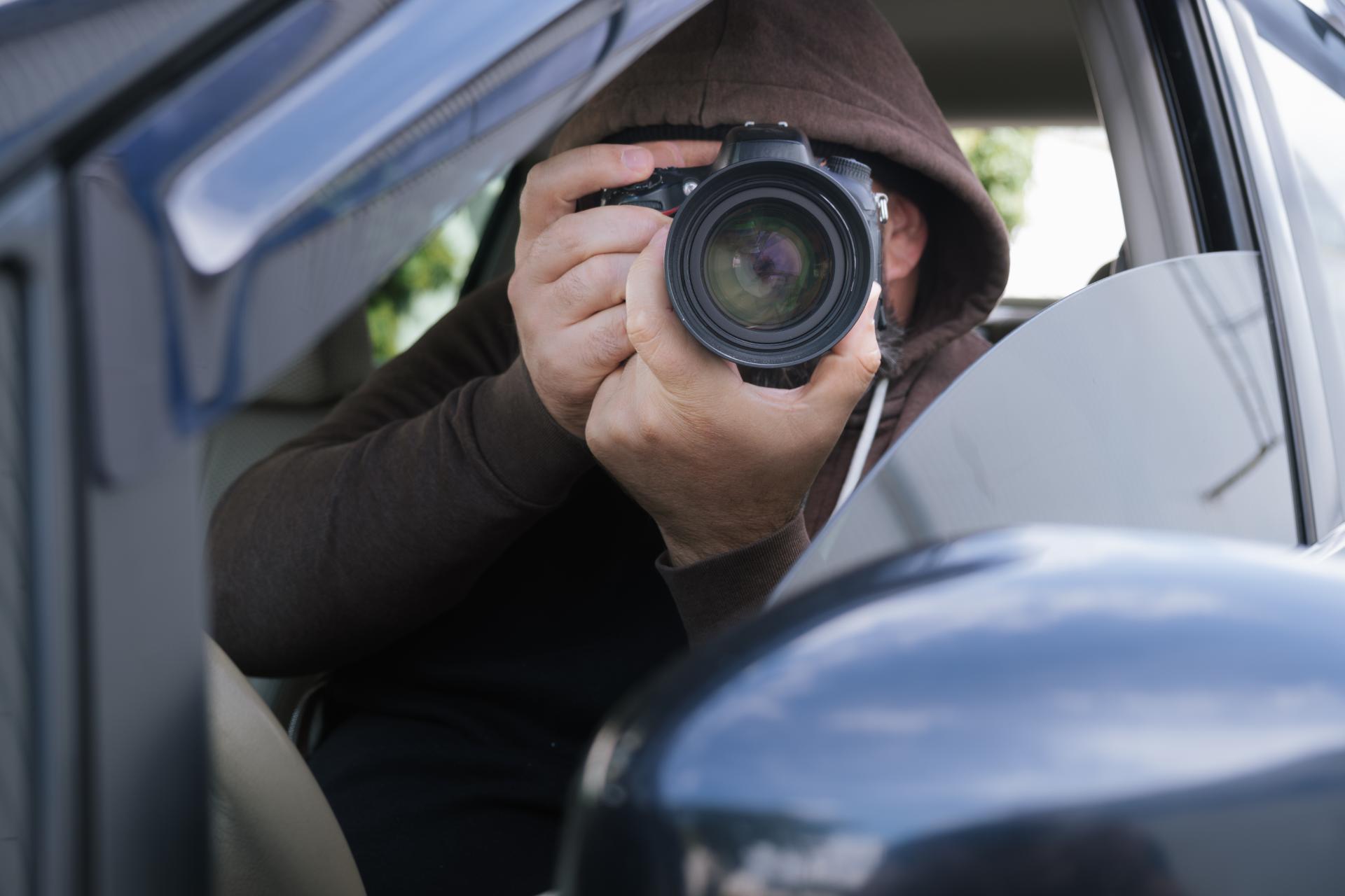 Investigatore privato durante investigazioni anti stalking con macchina fotografica per raccolta prove